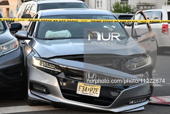 A vehicle is being damaged from bullet holes in the windshield at the crime scene on Saturday morning. Three people are being shot in Paters...