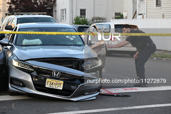 A vehicle is being damaged from bullet holes in the windshield at the crime scene on Saturday morning. Three people are being shot in Paters...