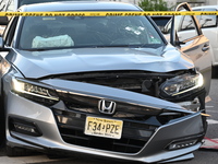 A vehicle is being damaged from bullet holes in the windshield at the crime scene on Saturday morning. Three people are being shot in Paters...