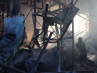 A rescuer is putting out a fire at an Epicentr K construction supermarket hit with two Russian glide bombs in Kharkiv, Ukraine, on May 25, 2...