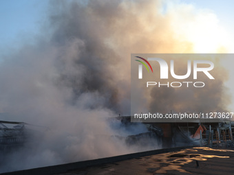 Smoke is rising over an Epicentr K construction supermarket hit with two Russian glide bombs in Kharkiv, Ukraine, on May 25, 2024. At least...