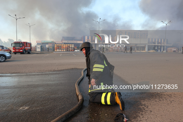 A rescuer is kneeling during a response effort outside an Epicentr K construction supermarket hit by two Russian glide bombs in Kharkiv, Ukr...