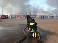 A rescuer is kneeling during a response effort outside an Epicentr K construction supermarket hit by two Russian glide bombs in Kharkiv, Ukr...