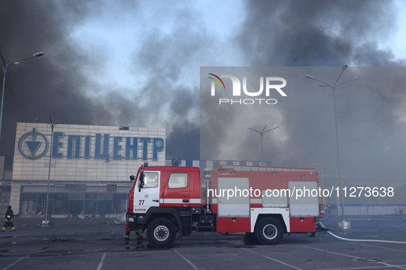 A fire engine is being seen outside an Epicentr K construction supermarket hit with two Russian glide bombs in Kharkiv, Ukraine, on May 25,...