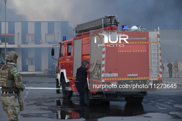 A fire engine is being seen outside an Epicentr K construction supermarket hit with two Russian glide bombs in Kharkiv, Ukraine, on May 25,...