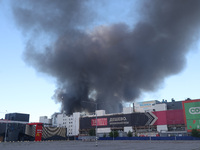 Smoke is rising over an Epicentr K construction supermarket hit with two Russian glide bombs in Kharkiv, Ukraine, on May 25, 2024. At least...