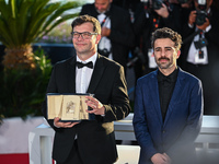 Nebojsa Slijepcevic (L) and a guest are posing with the 'Short Film Palme D'Or' Award for 'The Man Who Could Not Remain Silent' during the P...