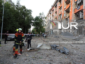 Rescuers are seen outside an office building destroyed by a Russian missile strike in central Kharkiv, Ukraine, on May 25, 2024. NO USE RUSS...