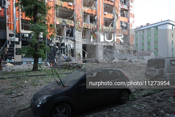 A damaged car is being seen opposite an office building destroyed in a Russian missile strike in central Kharkiv, Ukraine, on May 25, 2024....