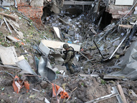 A law enforcer is exploring a crater at an office building destroyed by a Russian missile strike in central Kharkiv, northeastern Ukraine, o...