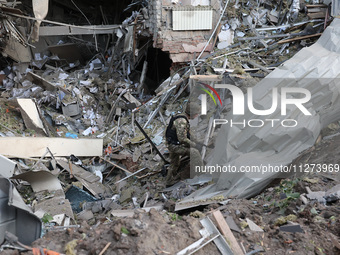 A law enforcer is exploring a crater at an office building destroyed by a Russian missile strike in central Kharkiv, northeastern Ukraine, o...