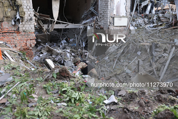 A law enforcer is exploring a crater at an office building destroyed by a Russian missile strike in central Kharkiv, northeastern Ukraine, o...