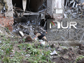 A law enforcer is exploring a crater at an office building destroyed by a Russian missile strike in central Kharkiv, northeastern Ukraine, o...