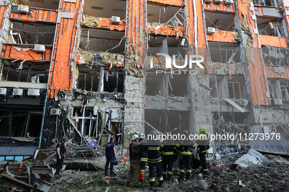 Rescuers are seen outside an office building destroyed by a Russian missile strike in central Kharkiv, Ukraine, on May 25, 2024. NO USE RUSS...