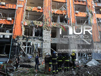 Rescuers are seen outside an office building destroyed by a Russian missile strike in central Kharkiv, Ukraine, on May 25, 2024. NO USE RUSS...