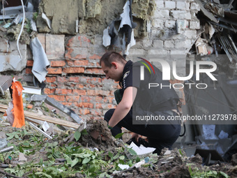 A police officer is exploring the premises of an office building destroyed by a Russian missile strike in central Kharkiv, Ukraine, on May 2...