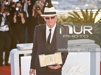 Jacques Audiard is posing with the 'Jury Prize' Award for 'Emilia Perez' during the Palme D'Or Winners Photocall at the 77th annual Cannes F...