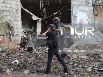 Police officers are exploring the premises of an office building destroyed by a Russian missile strike in central Kharkiv, Ukraine, on May 2...