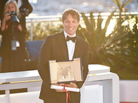 Sean Baker is posing with the 'Palme D'Or' Award for 'Anora' during the Palme D'Or Winners Photocall at the 77th annual Cannes Film Festival...