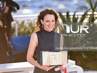Coralie Fargeat is posing with the 'Best Screenplay' award for 'The Substance' during the Palme D'Or Winners Photocall at the 77th annual Ca...
