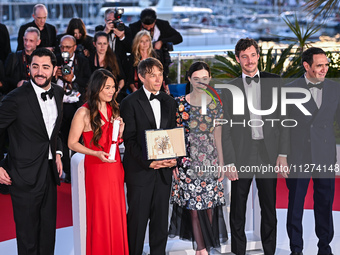 Karren Karagulian, Alex Coco, Mikey Madison, Sean Baker, Samantha Quan, and Vache Tovmasyan are posing with the 'Palme d'Or' Award for 'Anor...