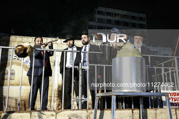 Ultra-Orthodox Jewish men watch a fire burn as they celebrate the Jewish holiday of Lag BaOmer in the Sheikh Jarrah neighborhood of Israeli-...