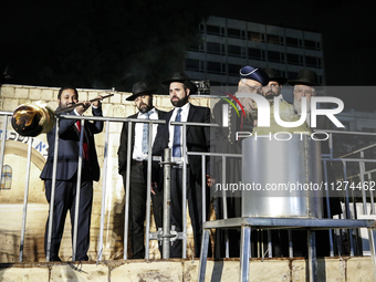 Ultra-Orthodox Jewish men watch a fire burn as they celebrate the Jewish holiday of Lag BaOmer in the Sheikh Jarrah neighborhood of Israeli-...