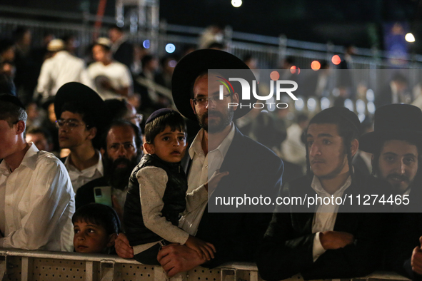 Ultra-Orthodox Jewish men watch a fire burn as they celebrate the Jewish holiday of Lag BaOmer in the Sheikh Jarrah neighborhood of Israeli-...