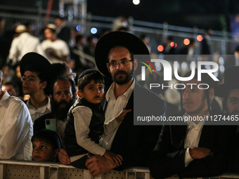 Ultra-Orthodox Jewish men watch a fire burn as they celebrate the Jewish holiday of Lag BaOmer in the Sheikh Jarrah neighborhood of Israeli-...