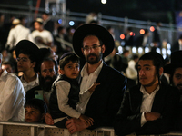 Ultra-Orthodox Jewish men watch a fire burn as they celebrate the Jewish holiday of Lag BaOmer in the Sheikh Jarrah neighborhood of Israeli-...