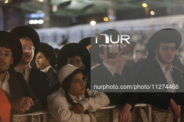 Ultra-Orthodox Jewish men watch a fire burn as they celebrate the Jewish holiday of Lag BaOmer in the Sheikh Jarrah neighborhood of Israeli-...