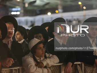 Ultra-Orthodox Jewish men watch a fire burn as they celebrate the Jewish holiday of Lag BaOmer in the Sheikh Jarrah neighborhood of Israeli-...