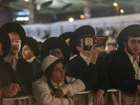 Ultra-Orthodox Jewish men watch a fire burn as they celebrate the Jewish holiday of Lag BaOmer in the Sheikh Jarrah neighborhood of Israeli-...