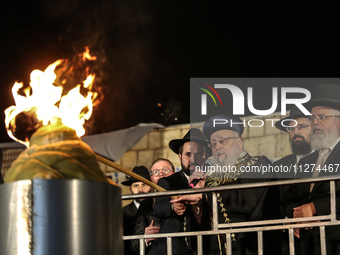 Ultra-Orthodox Jewish men watch a fire burn as they celebrate the Jewish holiday of Lag BaOmer in the Sheikh Jarrah neighborhood of Israeli-...