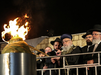 Ultra-Orthodox Jewish men watch a fire burn as they celebrate the Jewish holiday of Lag BaOmer in the Sheikh Jarrah neighborhood of Israeli-...