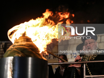 Ultra-Orthodox Jewish men watch a fire burn as they celebrate the Jewish holiday of Lag BaOmer in the Sheikh Jarrah neighborhood of Israeli-...