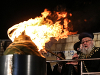 Ultra-Orthodox Jewish men watch a fire burn as they celebrate the Jewish holiday of Lag BaOmer in the Sheikh Jarrah neighborhood of Israeli-...