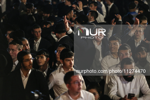 Ultra-Orthodox Jewish men watch a fire burn as they celebrate the Jewish holiday of Lag BaOmer in the Sheikh Jarrah neighborhood of Israeli-...