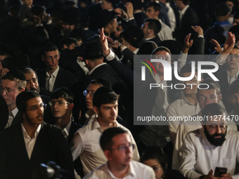 Ultra-Orthodox Jewish men watch a fire burn as they celebrate the Jewish holiday of Lag BaOmer in the Sheikh Jarrah neighborhood of Israeli-...