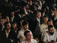 Ultra-Orthodox Jewish men watch a fire burn as they celebrate the Jewish holiday of Lag BaOmer in the Sheikh Jarrah neighborhood of Israeli-...