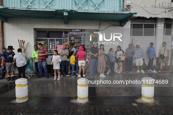 Residents of Culhuacan in the far south of Mexico City are sheltering from the rain during a procession to the Sanctuary of the Lord of Calv...