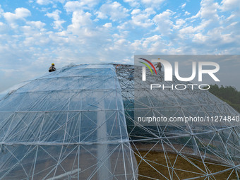 Workers are building a new spherical greenhouse in Hefei, Anhui province, China, on May 25, 2024. After the completion of the spherical gree...