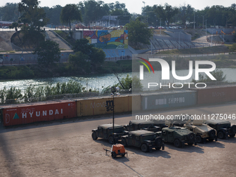 Texas National Guard vehicles are seen parked in Shelby Park, a public park in Eagle Pass, Tx., from a pedestrian bridge at a port of entry...