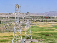 Construction workers are erecting a power grid at a height at the Bazhou-Tieganlik-Ruoqiang 750 kV transmission line project site in Korla,...