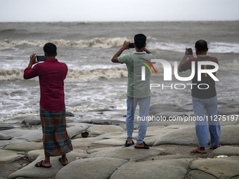 Tourists are filming the waves with their mobile phones at Kuakata Sea Beach in southern Bangladesh on May 26, 2024, as Cyclone Remal nears....