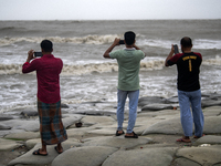 Tourists are filming the waves with their mobile phones at Kuakata Sea Beach in southern Bangladesh on May 26, 2024, as Cyclone Remal nears....