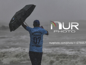 A man is taking a picture at Kuakata sea beach area in Kuakata, Bangladesh, on May 26, 2024, ahead of Cyclone Remal landfall in the coastal...