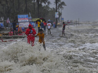 People are gathering on an embankment in Kuakata, on May 26, 2024, ahead of the landfall of Cyclone Mocha. India and Bangladesh are deployin...