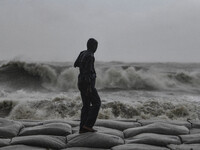 A man is standing on an embankment in Kuakata, Bangladesh, on May 26, 2024, during Cyclone Remal landfall. (