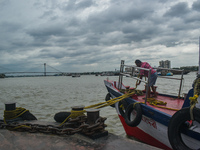 A person is tying his boat to the jetty during the high alert of Cyclone Remal in Kolkata, India, on May 26, 2024. Cyclone Remal is intensif...